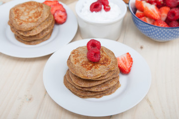 Breakfast: paleo style grain free banana almond pancakes, coconut yogurt with berries, selective focus