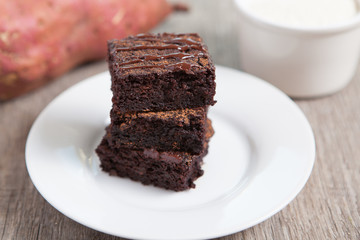 Healthy gluten free brownies made with sweet potato and coconut flour. Paleo style brownies on a wooden table, selective focus