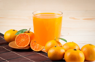 Orange juice and slices on wood