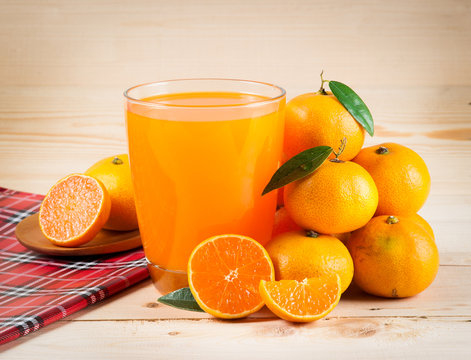 Orange juice and slices on wood