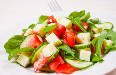 Fresh salad with tomatoes, arugula, cucumber and cheese cubes