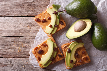 Beautiful sandwiches with avocado, peanut butter and raisins. horizontal top view
