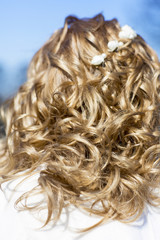 Свадебная прическа со спины. Локоны волос девушки падают на спину. 