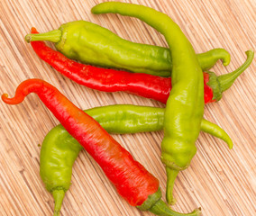 red and green hot peppers on a wooden background