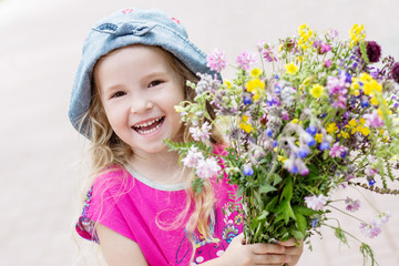 Happy toddler girl holding a bouquet