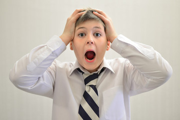 Teen boy screaming holding his hands behind  head