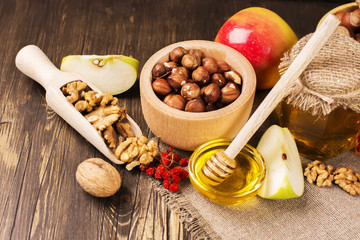 Obraz na płótnie Canvas Autumn or harvest concept: assortment of nut, apples and honey. Selective focus