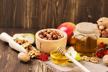 Autumn or harvest concept: assortment of nut, apples and honey. Selective focus