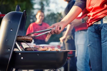 Foto op Plexiglas Tailgating: Man Grilling Sausages And Other Food For Tailgate Pa © seanlockephotography