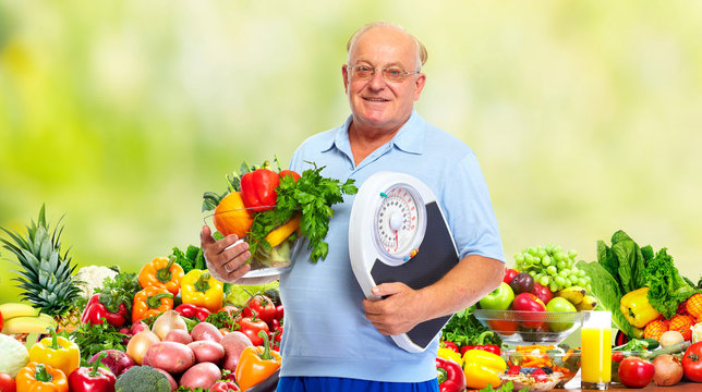 Senior man with scales and vegetables.