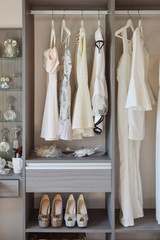row of white dress with shoes in wardrobe at home