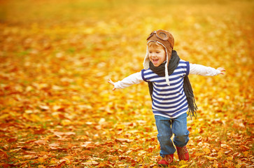 happy child playing pilot aviator outdoors in autumn