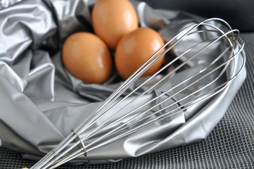whisk with eggs on silver color