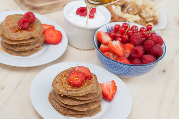 Breakfast: paleo style grain free banana almond pancakes, coconut yogurt with berries, selective focus