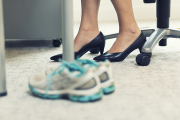 Close up of a business woman sports shoes in an office