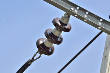 PORCELAIN INSULATOR - SUSPENSION INSULATORS IN NATURE DAY LIGHT (SELECTIVE FOCUS)
