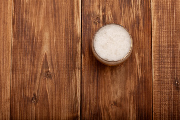 A glass of beer on the background of the wooden planks.