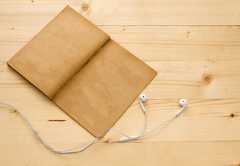vintage old book and earphone on wood table