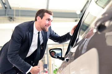 Autoverkäufer in einem Autohaus - Geschäftsmann  berät Kunden // salesman at a car dealership
