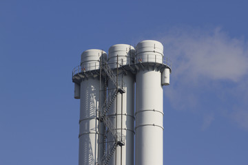 triple tube emits smoke against the blue sky