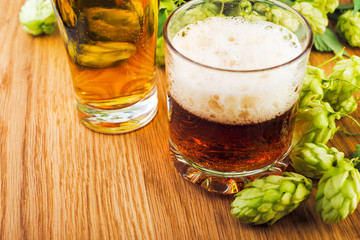 Fresh  green hops with beer on wooden table