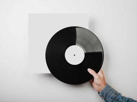 Male Hand Holding Vinyl Music Album Template On White Wall Backg