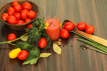 Fototapeta na wymiar tomatoes and glass of tomato juice on the table