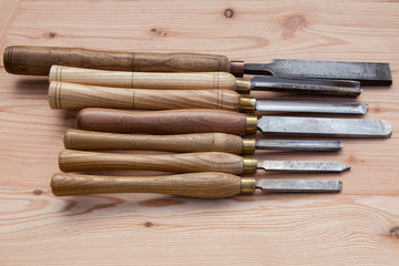 Old used wood lathe chisels selection on the wooden table, selective focus