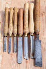 Old used wood lathe chisels selection on the wooden table, selective focus