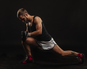 Athletic bearded boxer with gloves on a dark background - 91207680
