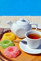 Cup of tea with a teapot and colored marmalade