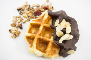 Waffles with chocolate, nut and granola on white background.