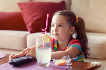 Obraz na płótnie Canvas cute little girl watching tv at home