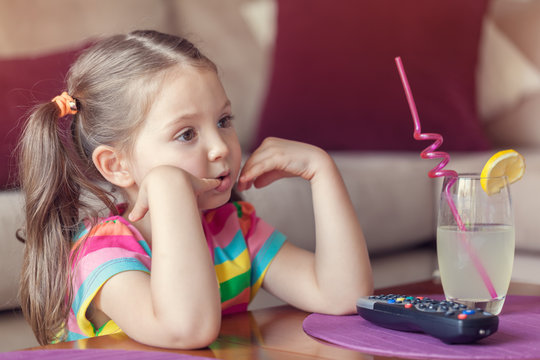 cute little girl watching tv at home