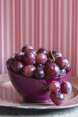 Fresh red grapes in a purple bowl