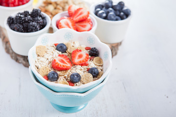 Breakfast: oatmeal cereals with berries on the white wooden table, selective focus