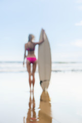 Fototapeta na wymiar beautiful girl with long hair on the beach with surfboard