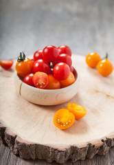 Red and orange cherry tomatoes on the dark wooden table