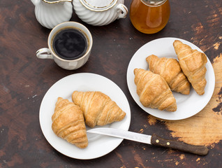 Croissants and jam on the dark wooden table