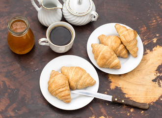 Croissants and jam on the dark wooden table