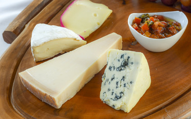 Different types of cheese on wooden kitchen board