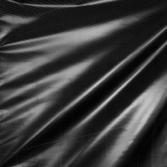  Black drape. Wavy folds of synthetic material.