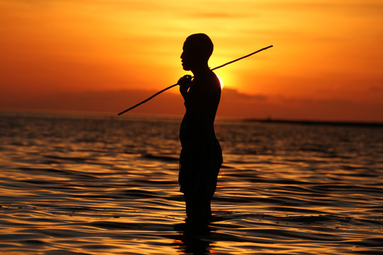 Silhouette of a man with a fishing stick on Lake Turkana at sunset
