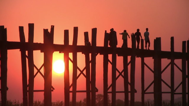 U Bein Bridge at sunset with people crossing Ayeyarwady River, Mandalay, Myanmar
