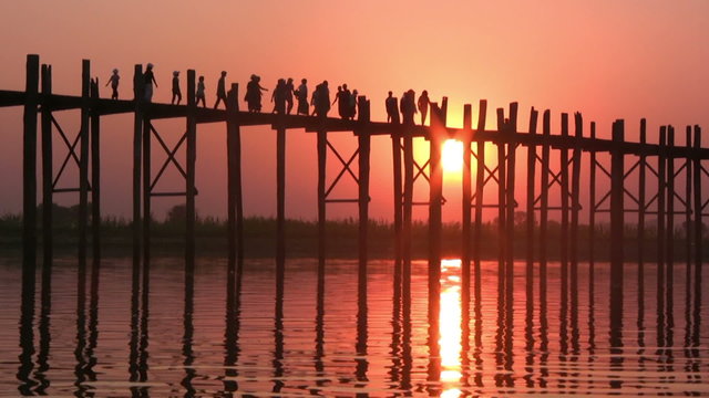 U Bein Bridge at sunset with people crossing Ayeyarwady River, Mandalay, Myanmar
