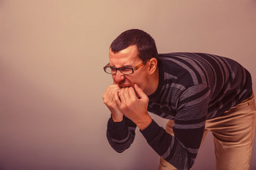 male of European appearance brunet put fingers in his mouth on a