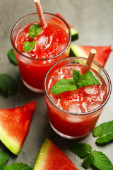 Cold watermelon drinks in glasses, on dark background