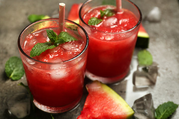 Cold watermelon drinks in glasses, on dark background