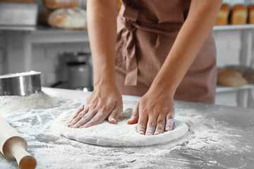 Making dough by female hands at bakery