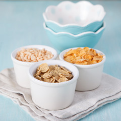 Mixed cereals in the blue bowl with empty bowls on the backgroun